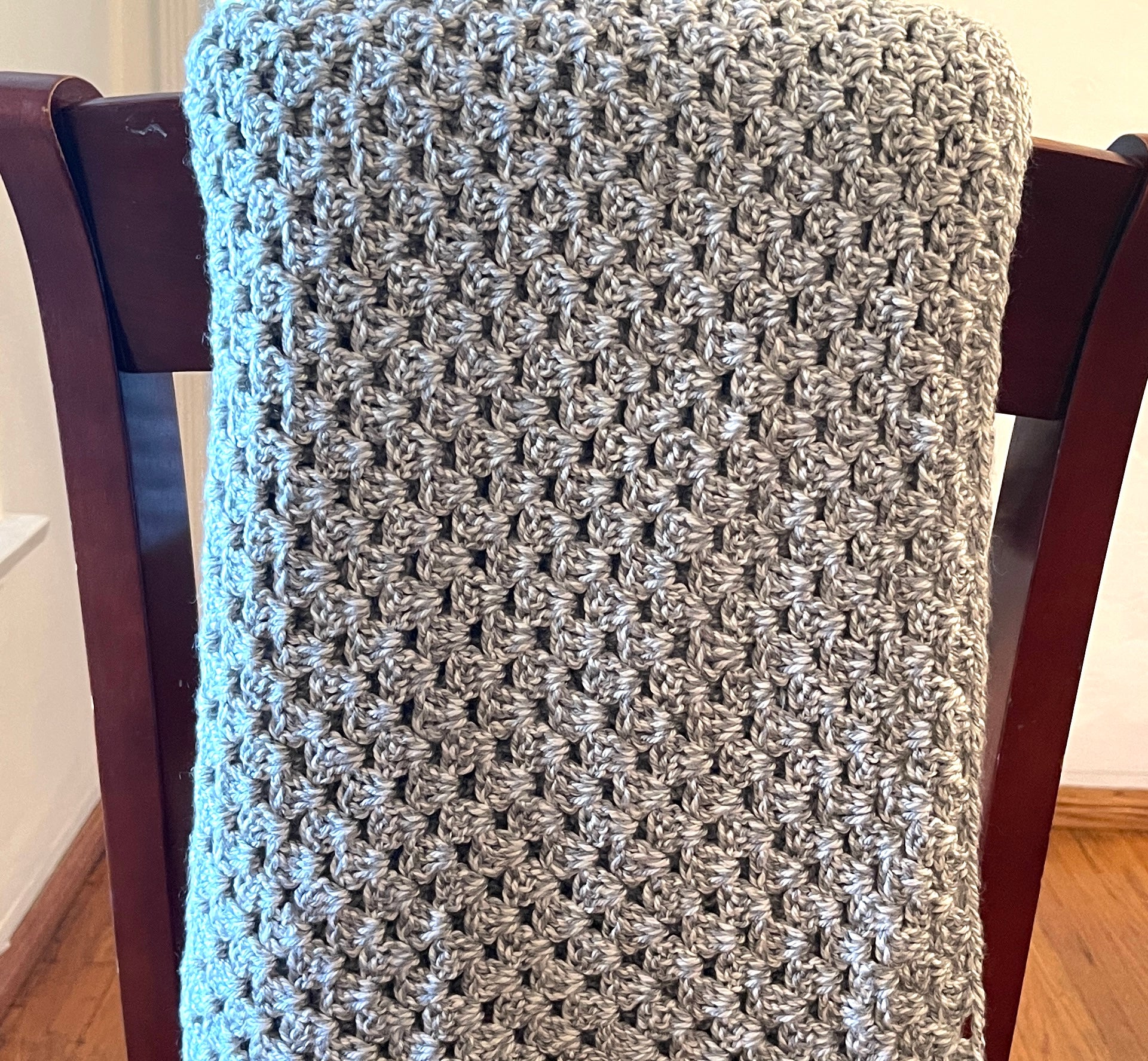 A handmade crochet afghan in heather gray and white , made with 100% Premium acrylic , size 59 x 68, washable and air dry