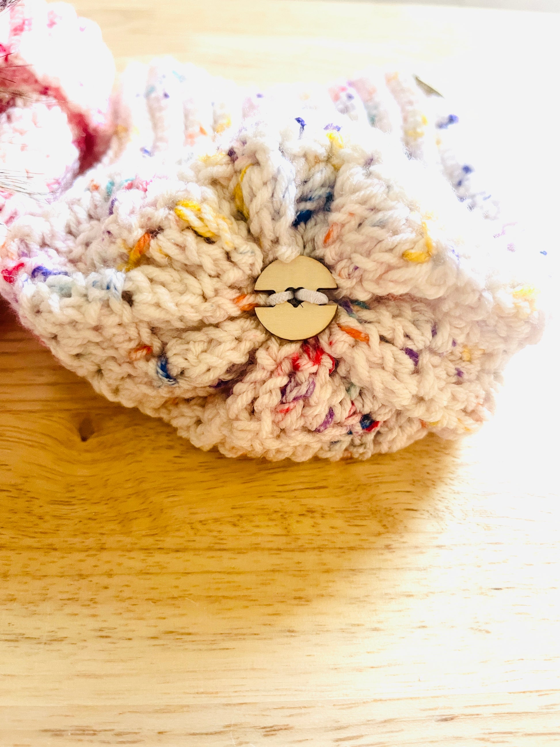 Showing the top of toddler beanie where the detachable pom pom goes